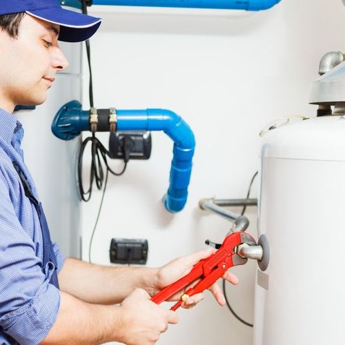 Plumber works on water heater.