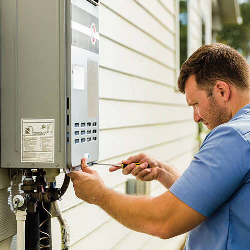 Plumber works on tankless water heater.