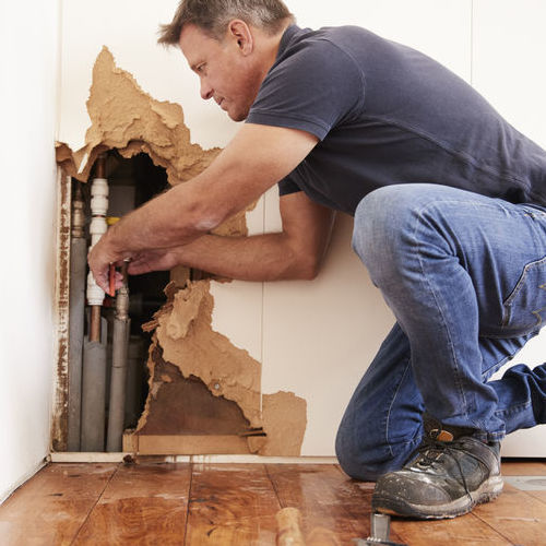 Emergency plumber works on burst pipes.