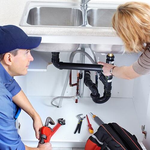 Emergency plumber talks to customer about repairs.